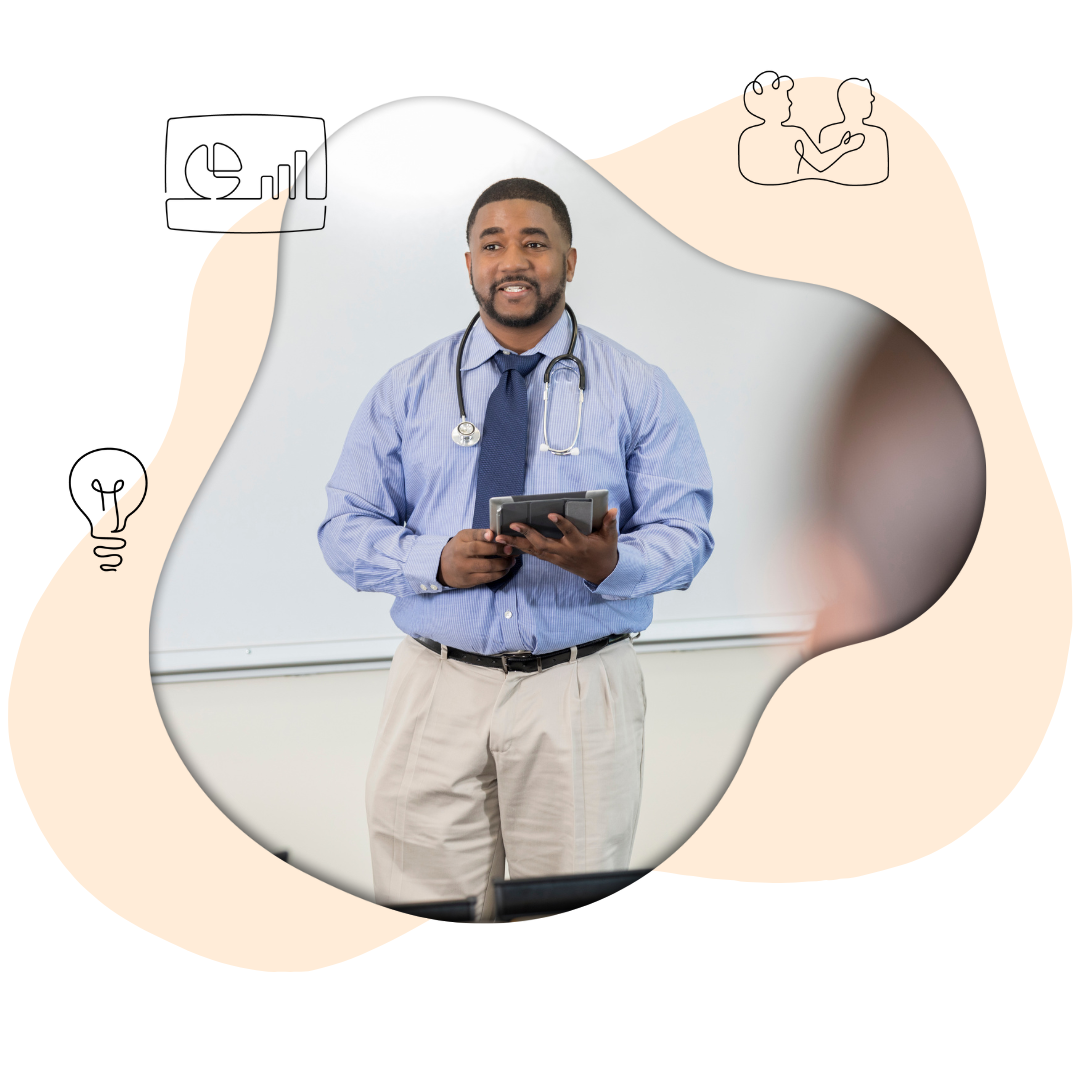 A man with a stethoscope around his neck standing holding a notepad appearing to deliver a lecture about emotional intelligence in a university health care system.